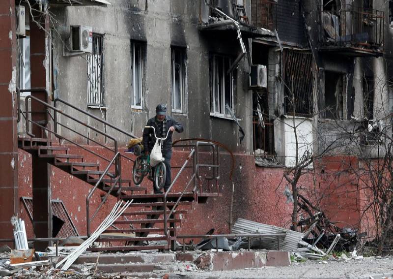 A man walks downstairs outside a residential building damaged during Ukraine-Russia conflict in the southern port city of Mariupol, Ukraine April 21, 2022. 