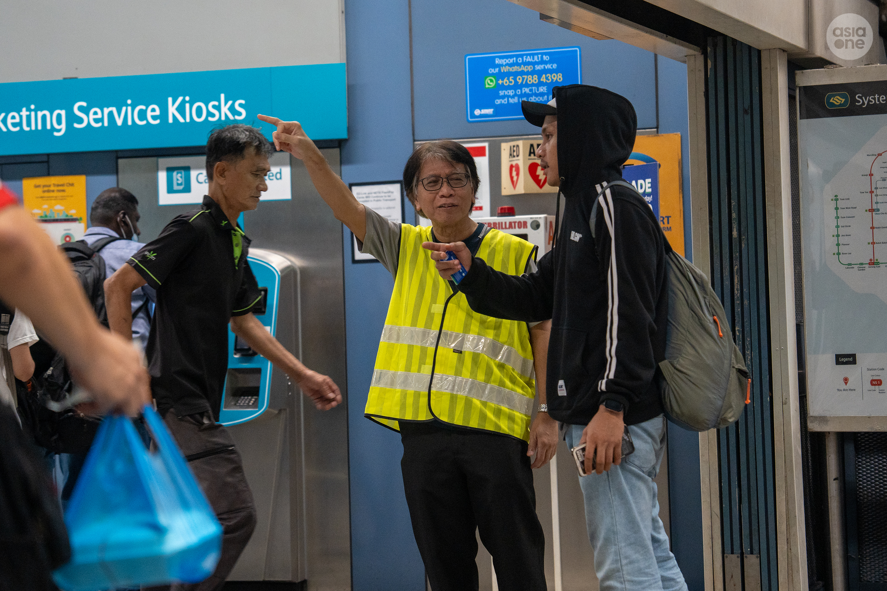 An SMRT service ambassador giving directions to a commuter at Clementi MRT station. 